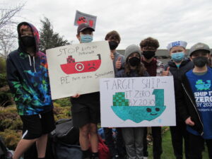 Youth Ship It Zero activists holding signs calling for Target to end its fossil-fueled shipping pollution.